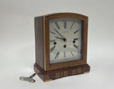 A modern Comitti of London Art Deco-style wooden mantle clock raised on bracket feet, with turning