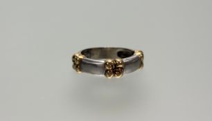 Garrard & Co., an 18ct white and yellow gold ring, the domed band set with three yellow gold four-