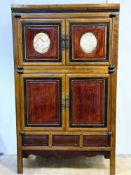 A late 19thc Chinese elm and pine cabinet, the upper inset panel stained wood doors with painted