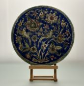 A large earthenware circular tile, Turkish, of Iznik type, decorated with birds and flowers.