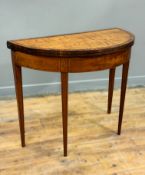 A Regency satinwood, mahogany and ebony strung demi lune foldover card table, with replaced baize