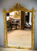 An Edwardian giltwood and composition pier glass in the French taste with scrolling fan shell