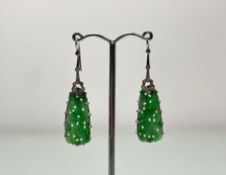 A pair of diamond-set jade pendent earrings, c. 1920-30, each claw-set with a tapered carved jade