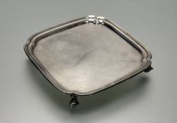 A George V silver card tray, Robert Stewart, Sheffield 1933, square, on scroll feet. 19cm square, 11