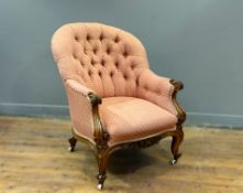 A Victorian light walnut button back drawing room country house style chair, with carved scroll arms