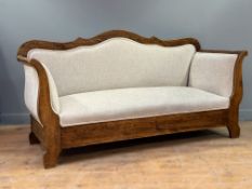 A 19thc French provincial pine sofa with curved cresting rail and scroll ends, on shaped tapered