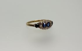 A sapphire and diamond cluster ring, early 20th century, set to the centre with a pair of round-