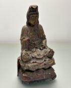 A Chinese carved wooden, gilt and red lacquered figure of Guanyin, her right hand raised in
