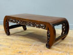 A Chinese Kang table in padouk wood, probably Qing Dynasty, with curved ends and pierced carved