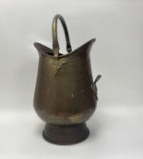 A large hammered brass coal/kindling scuttle with single handle to side and swing handle to top (