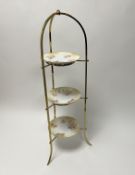 A brass cake-stand of three circular layers (h. 80cm), together with a set of three porcelain cake