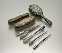 A Birmingham silver backed chased hair brush: l. x 25cm Birmingham 1906, two plated hair brushes,