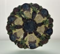 A Late 19thc Edward Bingham Castle Hedingham Pottery dish, decorated relief with masks and floral