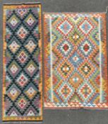 A set of two vibrant kilim rugs, each with repeating geometric diamond motifs enclosed within
