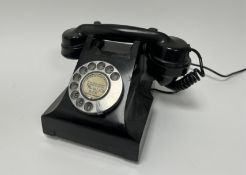 A mid 20thc black rotary telephone with spin dial (w. 23cm)