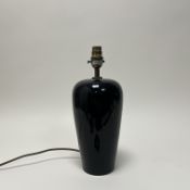 A modern black glazed ceramic table lamp with a paper pleated shade decorated with geometric paisley
