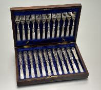 An Edwardian walnut canteen containing an unsual set of twelve pairs of epns engraved mother of