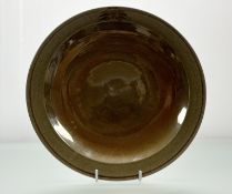 A Tobias Harrison (Contemporary 1950-), an earthenware plate with brown and green luster glaze
