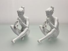 A pair of Kaiser German white porcelain figures of a seated nude female figure playing the flute (