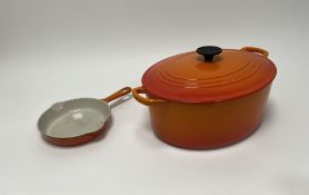 A Le Creuset cast iron enameled oval Dutch Oven in the 'volcanic' colourway (l. 39cm), together with