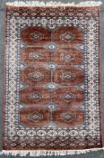 A Turkman Bokhara style rug, with ten octagonal panels to centre with stylized flowerhead motif,