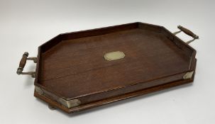 A mahogany octagonal tray with brass mounts and handles, and raised on four brass bun feet (l.