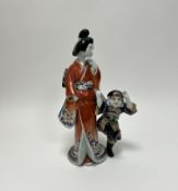 A late Meiji period Japanese porcelain figure of a woman and her son, dressed in red robes (repair
