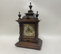 A late 19thc German HAC 14-day strike mantle clock within a carved wooden case, raised on four bun