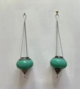 A pair of Middle Eastern hanging t-light holders/lanterns with green glass bowls and pierced
