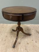 A reproduction oak drum table, inset brown skiver to top, three frieze drawers and three faux