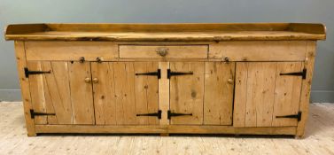 An early 20th century pine country house kitchen dresser, with ledge back and single frieze