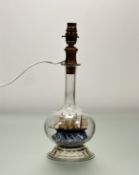A clear glass bottle table lamp with miniature bottle ship and a lampshade. (h- 34.5cm)