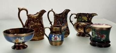 A collection of copper lustre ware comprising, two pitchers, one with painted blue bells the other