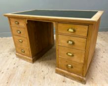 An early 20th century stripped pine desk, with green inset skiver to top and shaped apron to