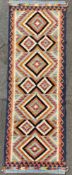 A hand-knotted Kilim runner, central panel with repeating diamond motifs, enclosed within a