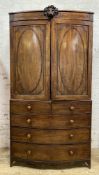 An impressive Georgian mahogany bow-front linen press, with carved lion mask to cornice over twin
