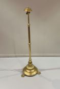 An Edwardian brass telescopic floor lamp with knopped detail and raised on three claw feet (h.