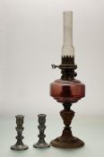 A Victorian brass fluted conrithian oil lamp with cranberry glass shade to base, marked Edina made