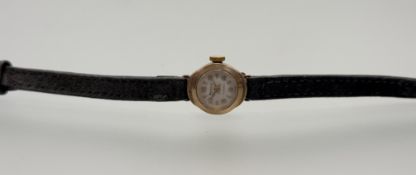 A 9ct gold Regency wristwatch with arabic numerals and baton hour markers on brown strap: d. x 1cm