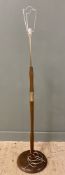 A modern wood veneered and aluminium standard lamp, central column with brass detail raised on a