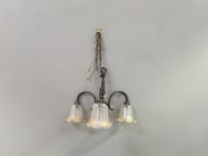 A Mid-Century ceiling light with a scrolling patinated metal frame supporting three etched tulip