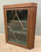 An Edwardian elm hanging corner cabinet, moulded top over an astragal glazed panel door, enclosing