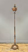 An early 20thc Arts and Crafts style copper floor standing lamp, the copper stem with turned and