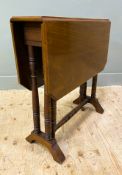 An Edwardian mahogany Sutherland table, with drop-leaves to top, over turned shaped supports on