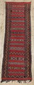 An antique hand-knotted kilim runner, with striped geometric panels to centre enclosed within a