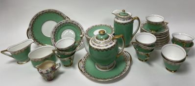 A Royal Doulton tea service decorated with floral and gilt border on a green and gilt ground