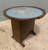 An early 20th century mahogany side table, with circular moulded tilt-top featuring a needlework