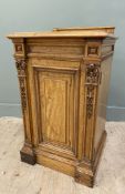 An Edwardian satinwood bedside cabinet, with ledge back over an inset panel door flanked by