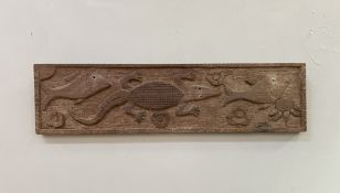 A hand-carved African wooden panel, with relief decoration of a crocodile, flanked by two fish and