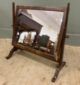 An Edwardian mahogany dressing table swing mirror, with rectangular plate and frame raised on square